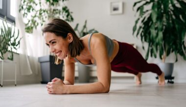 Woman setting up for plank rows exercise at home, smiling on floor