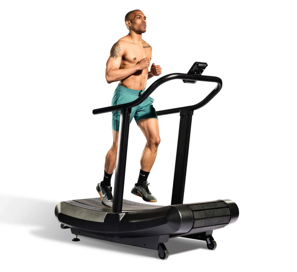 person running on a curved treadmill in athletic shorts and shoes person running on a curved treadmill in athletic shorts and shoes