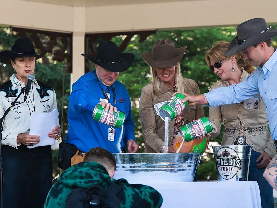 Aleta Visbach (left) explains the various ingredients that go into concocting the Trail Boss Tonic at the Legacy Stampede Breakfast at Heritage Park in Calgary on Sunday, July 5, 2026.