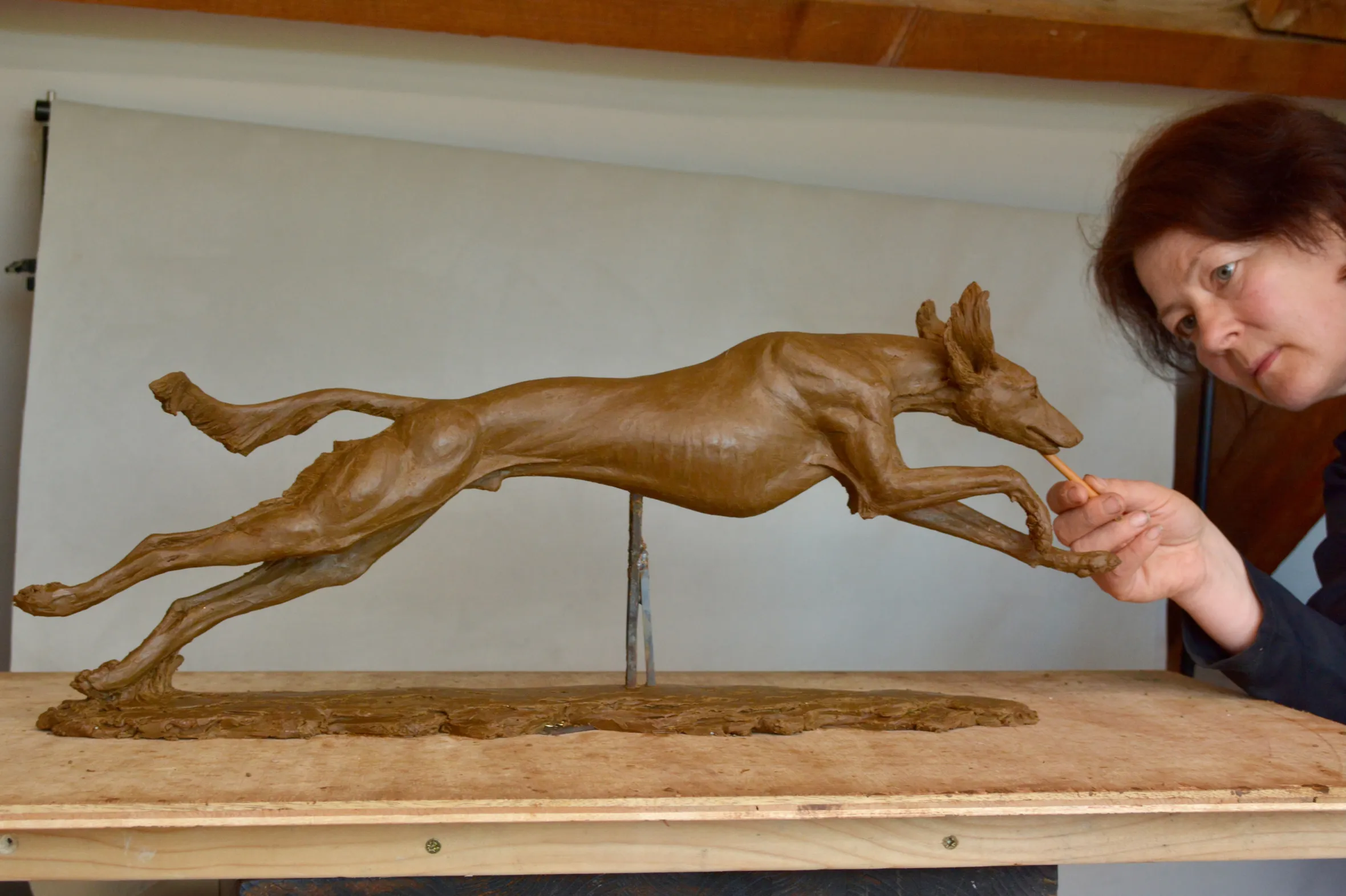 Tanya Russell creating a dog sculpture from clay.