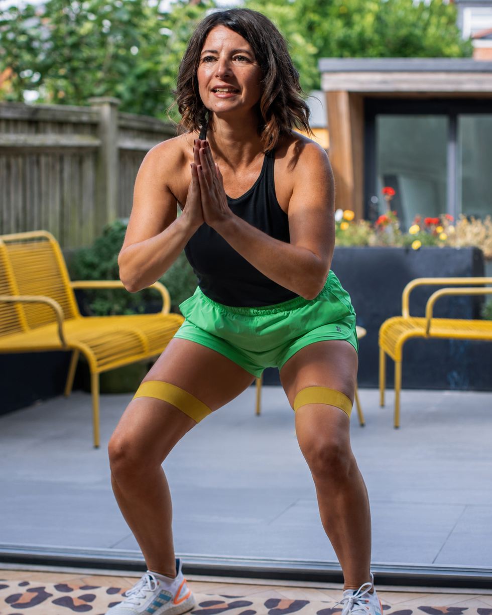 person exercising with resistance bands in an outdoor setting.
