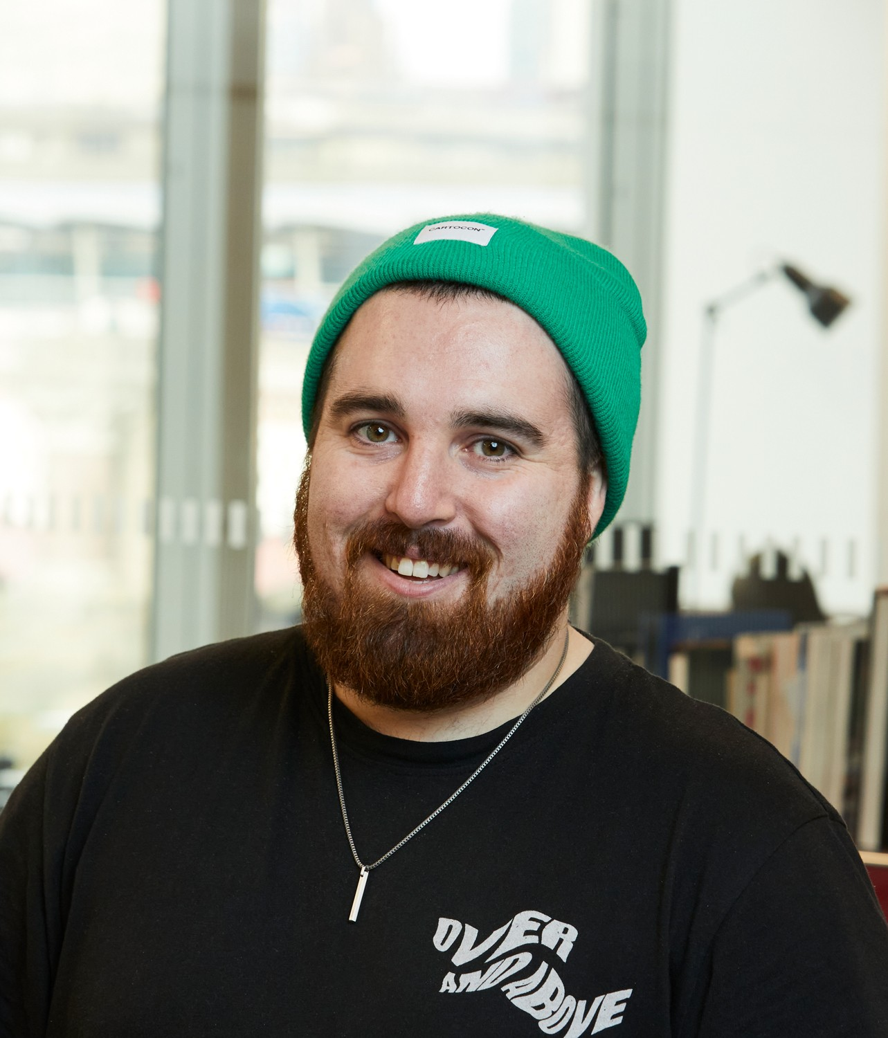 man with green beanie hat on and black top