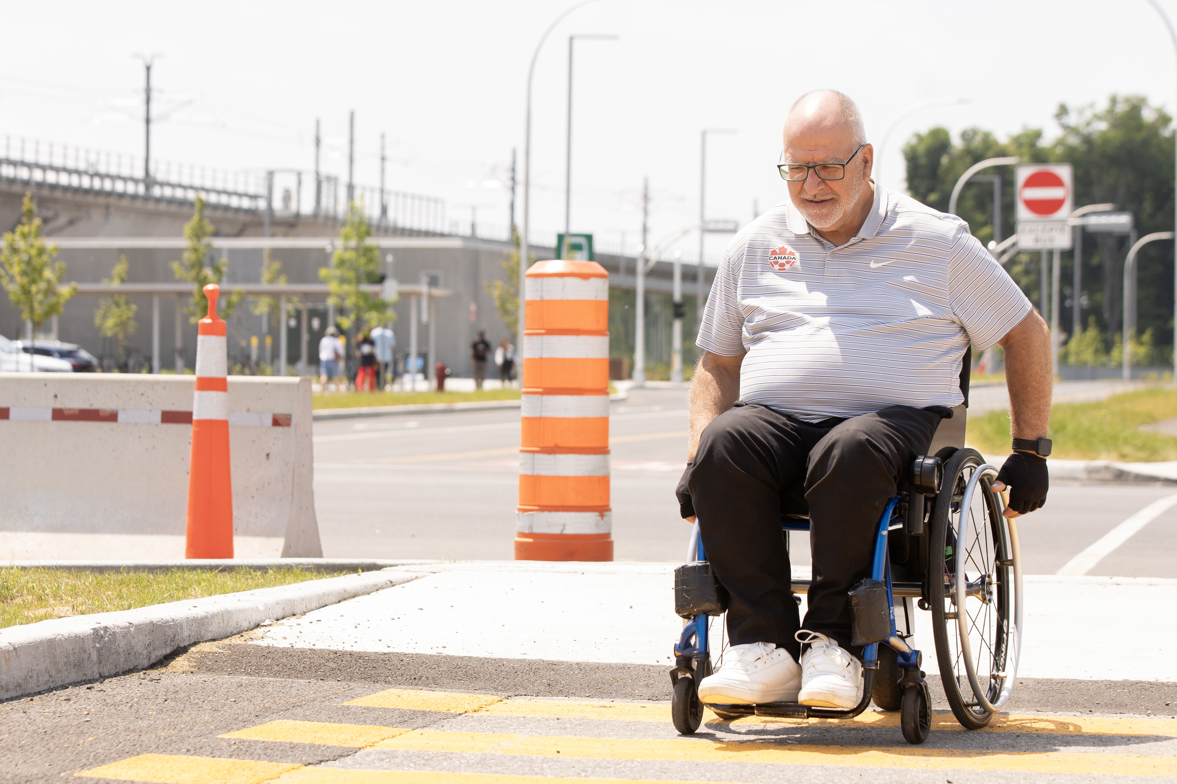 A man uses a wheelchair on a pedestrian crossing.