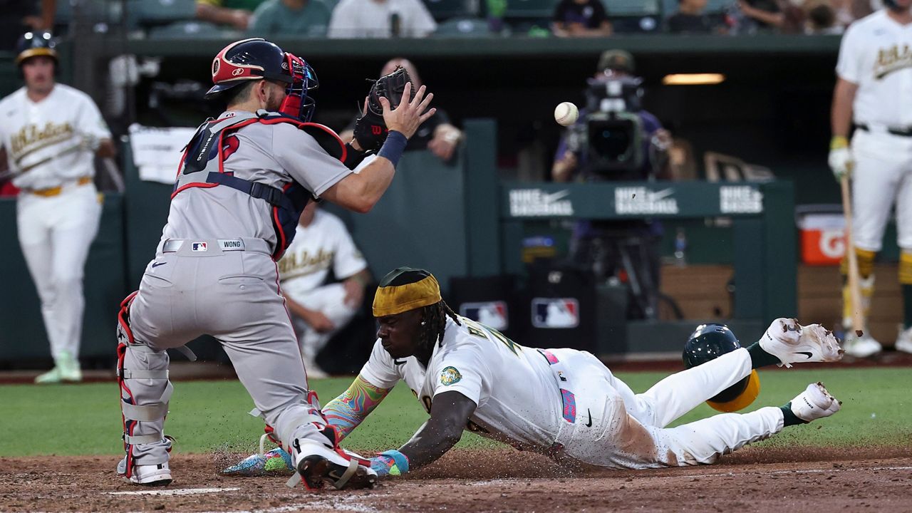 Boston Red Sox catcher Connor Wong, left, attempts to get Athletics' Lawrence Butler (4) out at home plate during the sixth inning of a baseball game Thursday, July 30, 2026, in West Sacramento, Calif. (AP Photo/Sara Nevis)