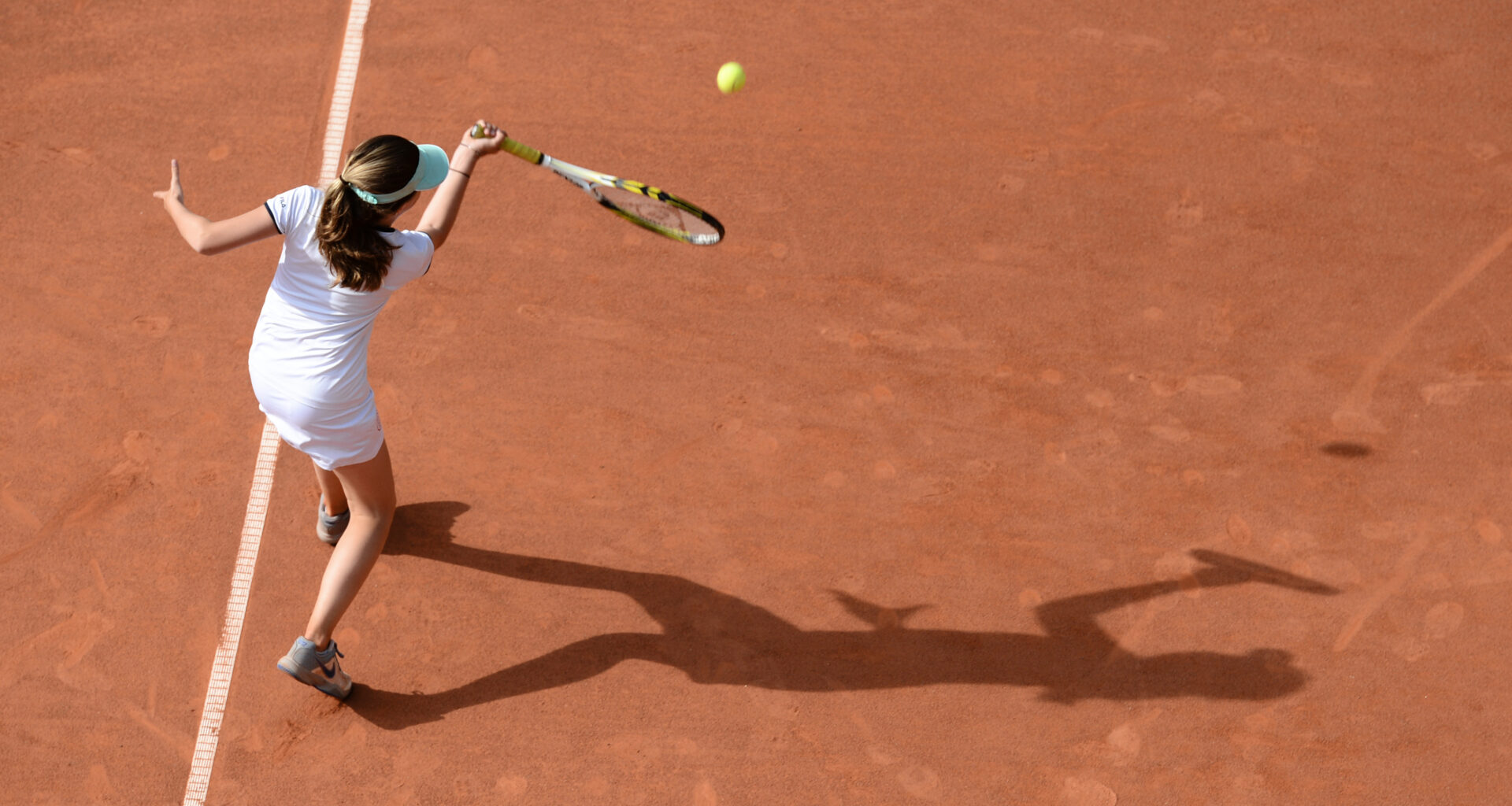 A young woman plays tennis in the light of the low-hanging sun and casts a long shadow in Hamburg, Germany, 09 June 2016. Photo by: Daniel Reinhardt/picture-alliance/dpa/AP Images