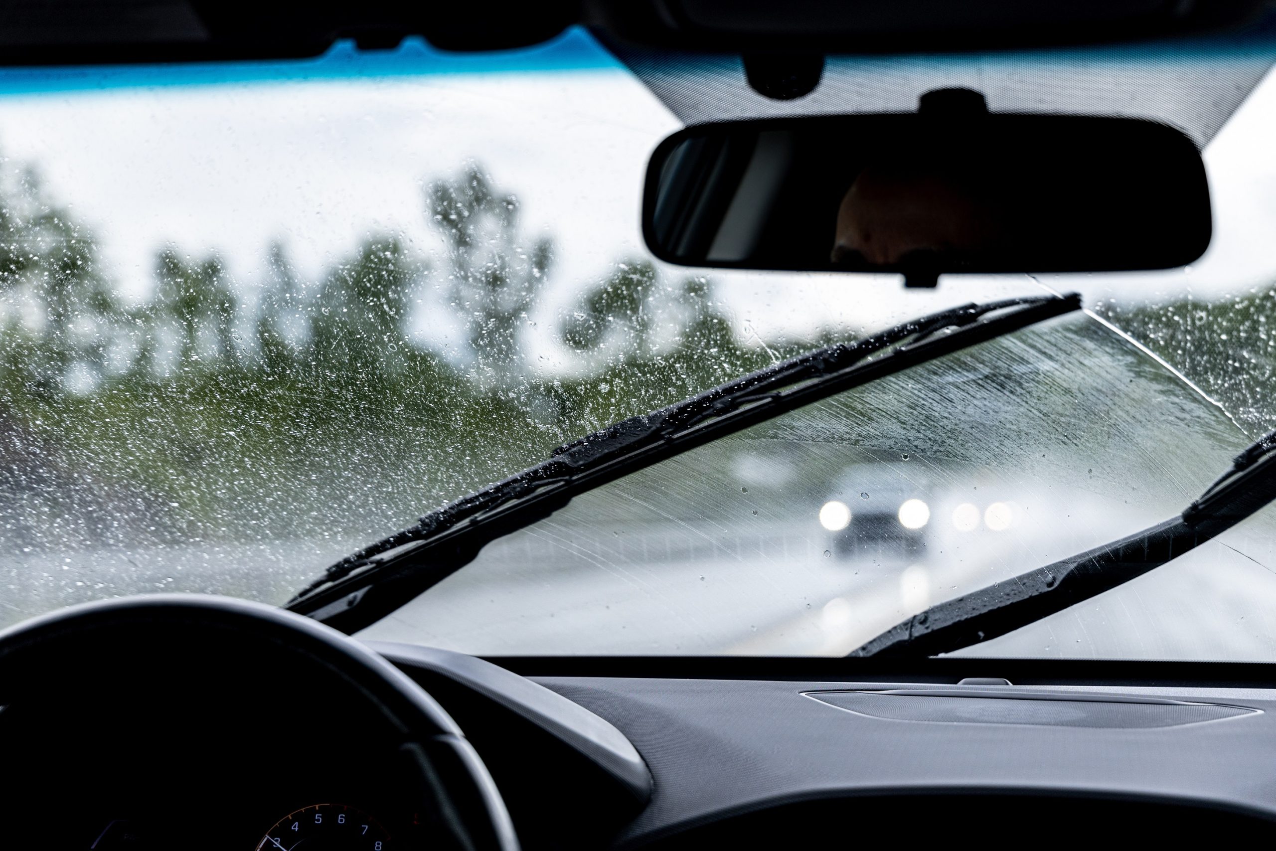 view of rain in a car with windshield wipers moving