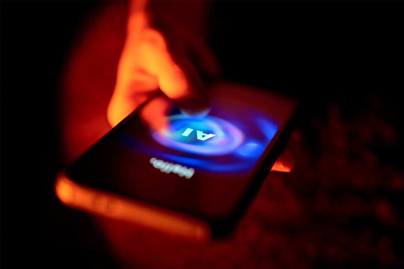 A hand touches the glowing screen of a smartphone showing an AI chatbot interface, illuminated in red and blue light.