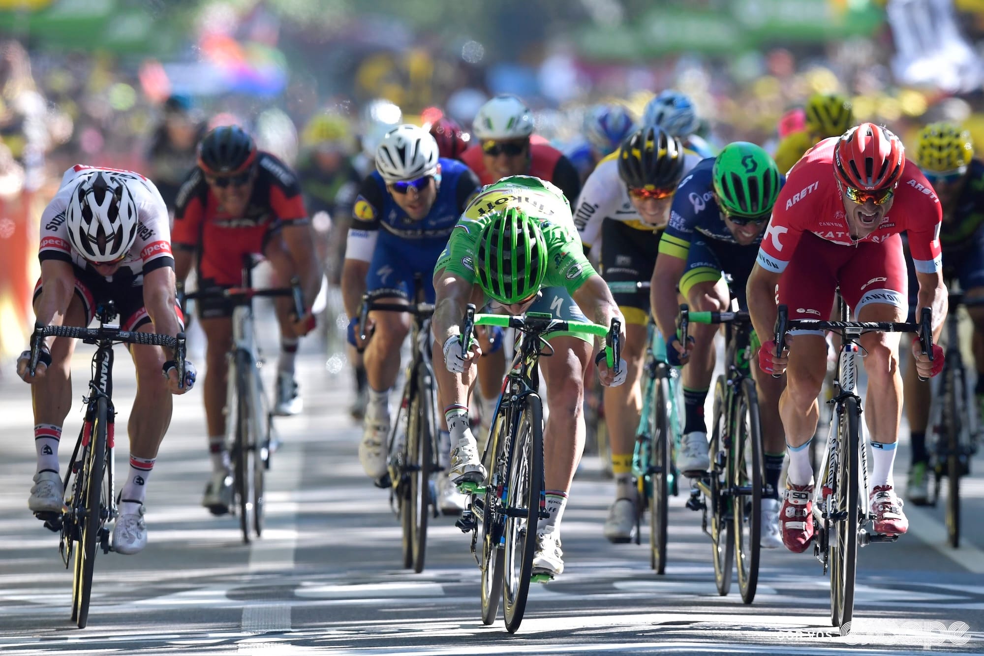 Sagan, in the Tour's green jersey, throws his bike to finish ahead of Kristoff, who is still in mid-pedal stroke.