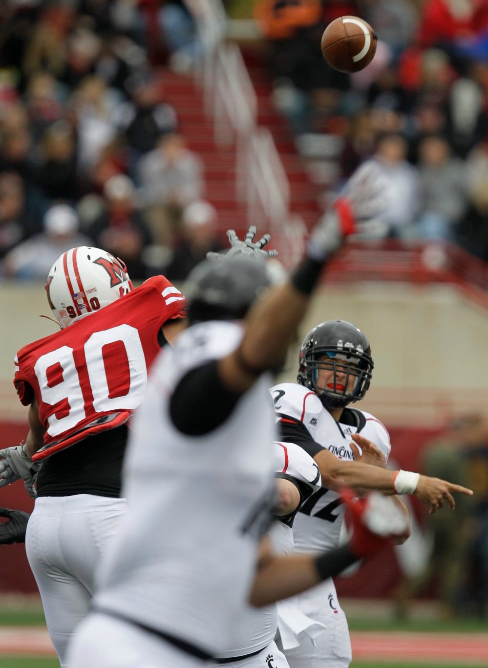 Cincinnati quarterback Zach Collaros (12) throws an 18-yard touchdown pass over Miami of Ohio defender Austin Brown (90) to tight end Travis Kelce, front, in the first half of an NCAA college football game, Saturday, Oct. 1, 2011, in Oxford, Ohio. Cincinnati won 27-0. (AP Photo/Al Behrman)