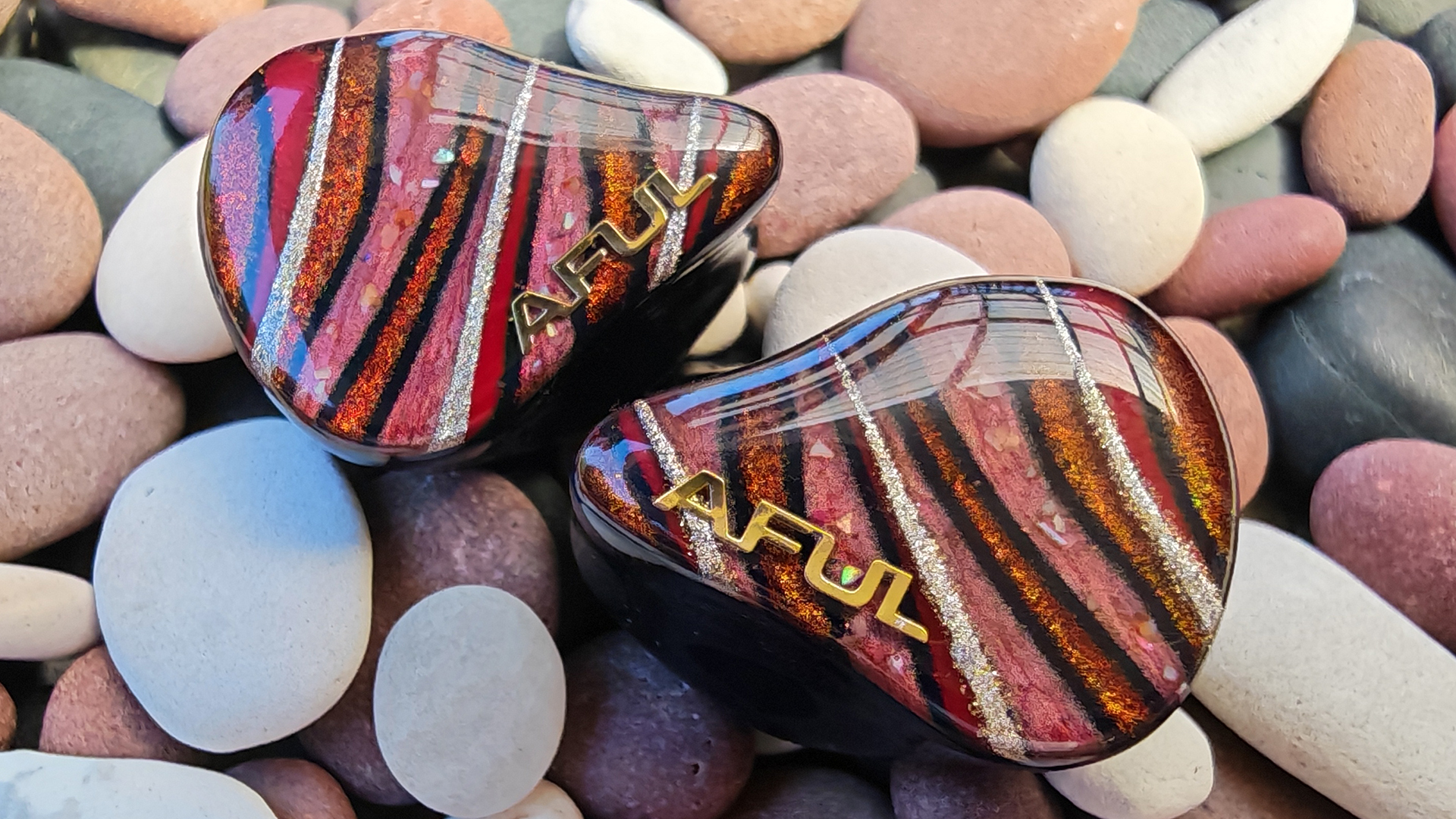 The Aful Performer 8s IEM on black and red pebbles. 