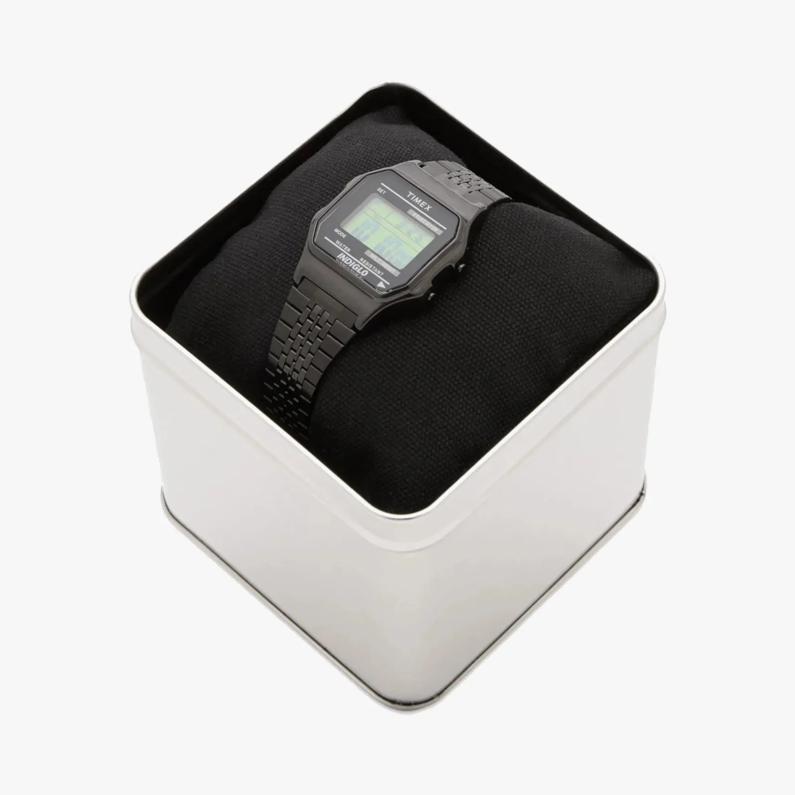 Black Timex digital watch with metal link band on a black cushion inside a silver metal box.