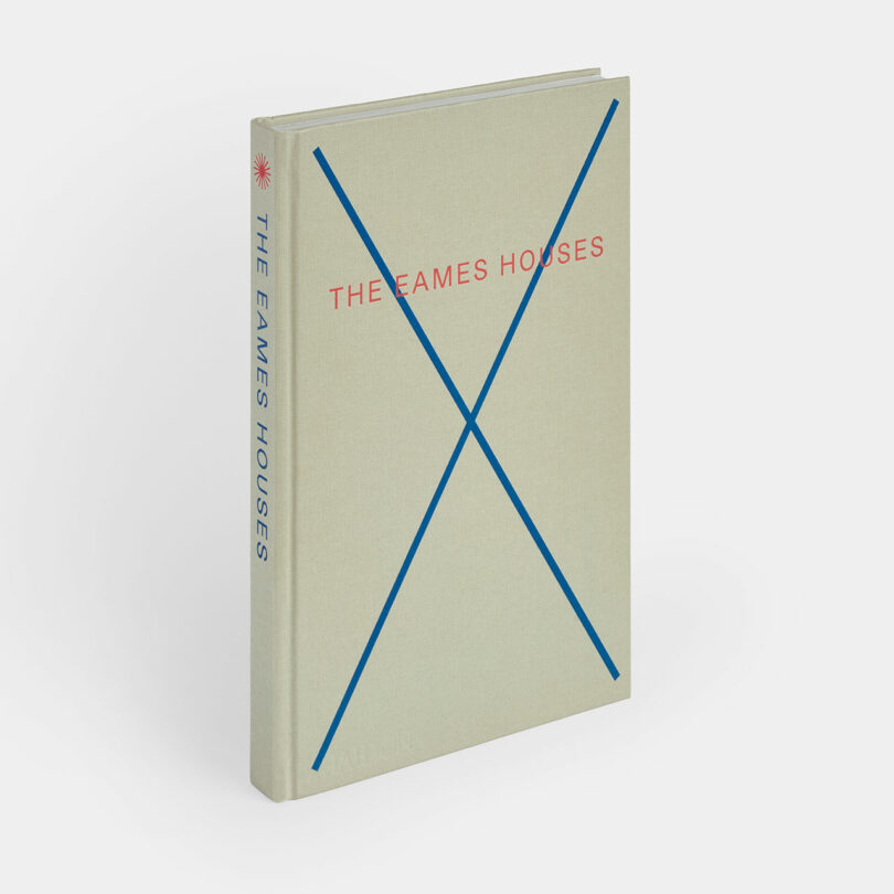 A hardcover book titled "The Eames Houses" with a beige cover, blue lines forming an X, and red and blue text on the front and spine.