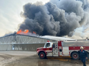 Norfolk County firefighters are scene at a massive structure fire at a hog farm on Highway 3 just west of Simcoe, Ontario. The structure - estimated at about four acres in size -- is a total loss, and at least 20,000 pigs have perished in the blaze that continues to burn on Tuesday morning, July 14, 2026.