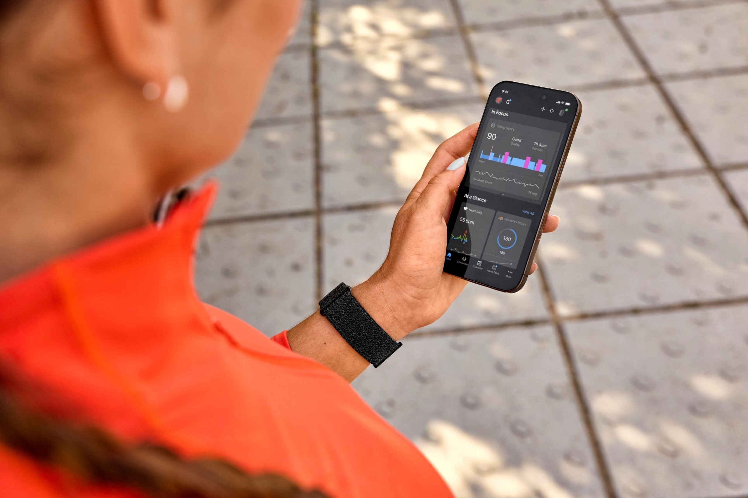 a person wearing the CIRQA Smart Band and checking the Garmin app to see their data.