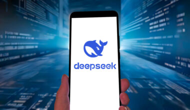 DeepSeek logo on a smartphone against a blue streaming-code tech-ish background.