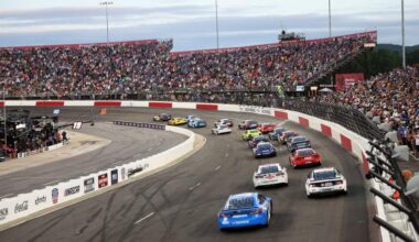 NASCAR Cup Series cars race in front of a packed grandstand during the All-Star Race at North Wilkesboro Speedway.