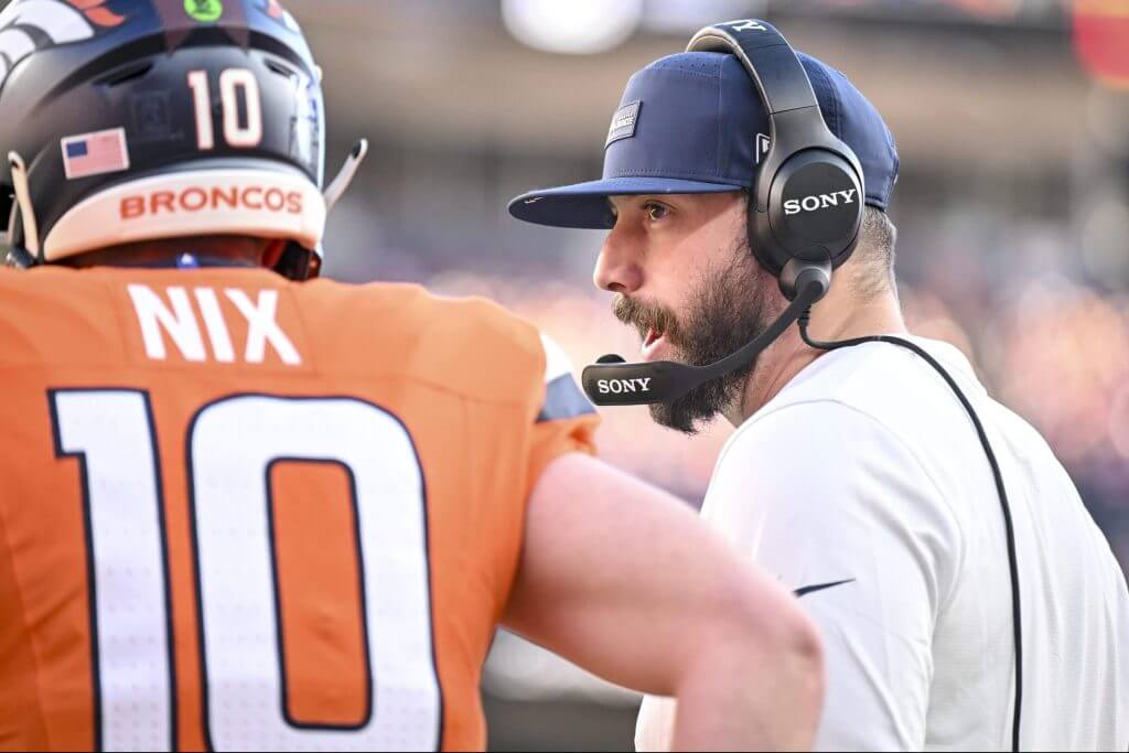 Denver Broncos assistant coach Davis Webb speaks to quarterback Bo Nix during a game in December, 2025.