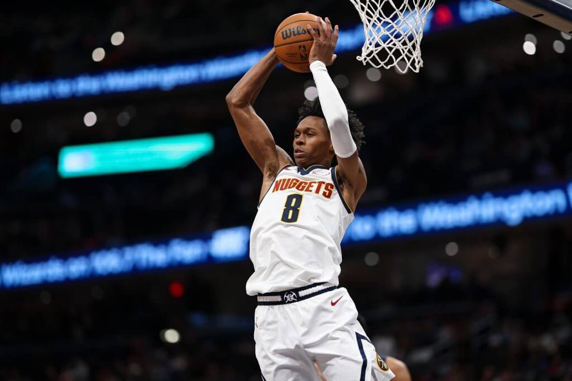 Denver Nuggets forward Peyton Watson jumps while holding the ball with both hands above his head during an NBA game.