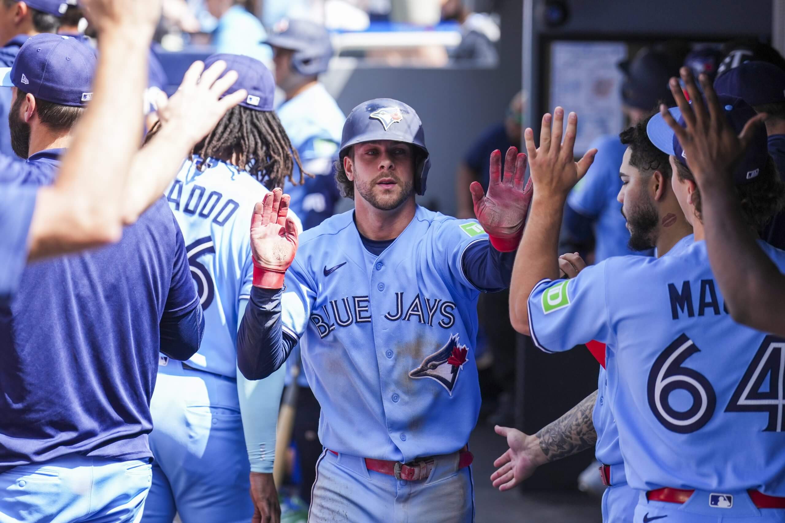 Ernie Clement is congratulated in the Blue Jays dugout.