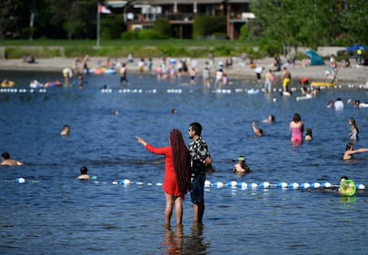 People swim in the Ottawa River on the Victoria Day long weekend at Britannia Beach in Ottawa on May 24, 2021. (Justin Tang / The Canadian Press)