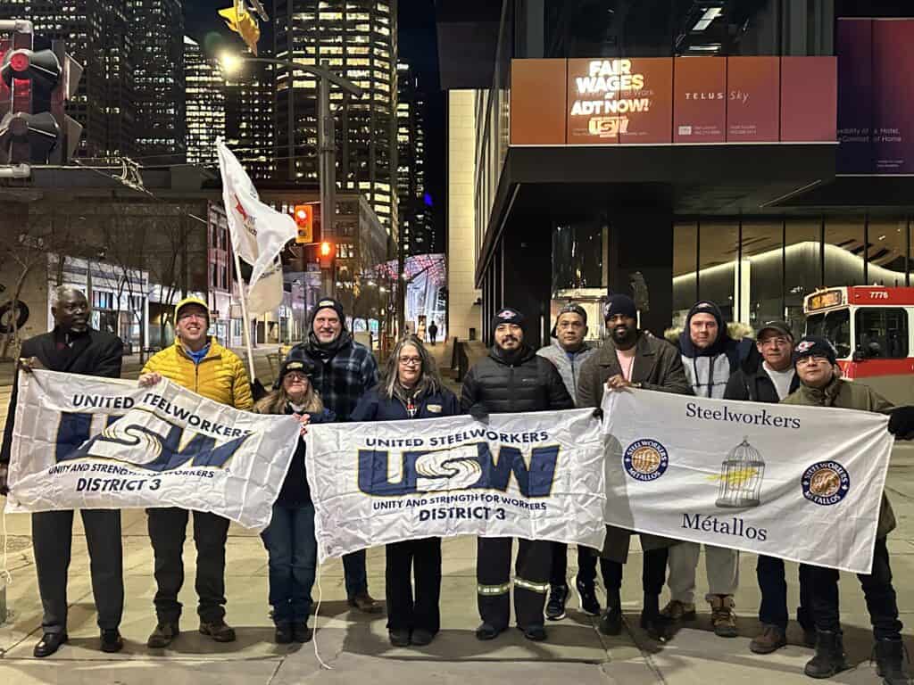 ADT by Telus Bat Light with members holding USW flags