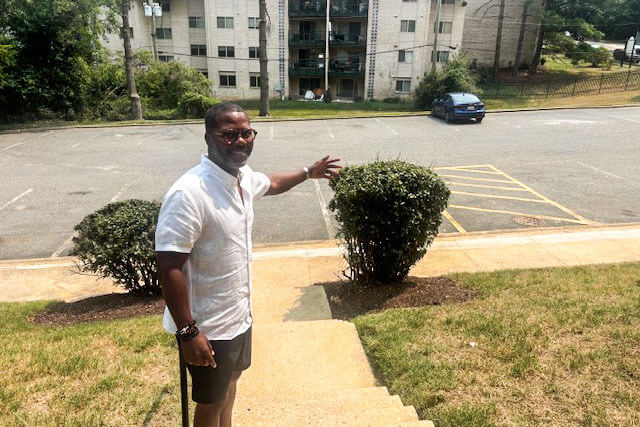 Daronte Jones in front of the apartment buildings near the Washington Commanders' home stadium where he once lived..
