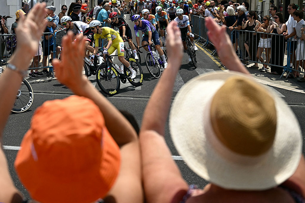 UAE Team Emirates - XRG's Slovenian rider Tadej Pogacar wearing the overall leader's yellow jersey cycles past spectators cheering along the race route during the 7th stage of the 113th edition of the Tour de France cycling race, 175,1 km between Hagetmau and Bordeaux in southwestern France, on July 10, 2026. (Photo by Loic VENANCE / AFP)