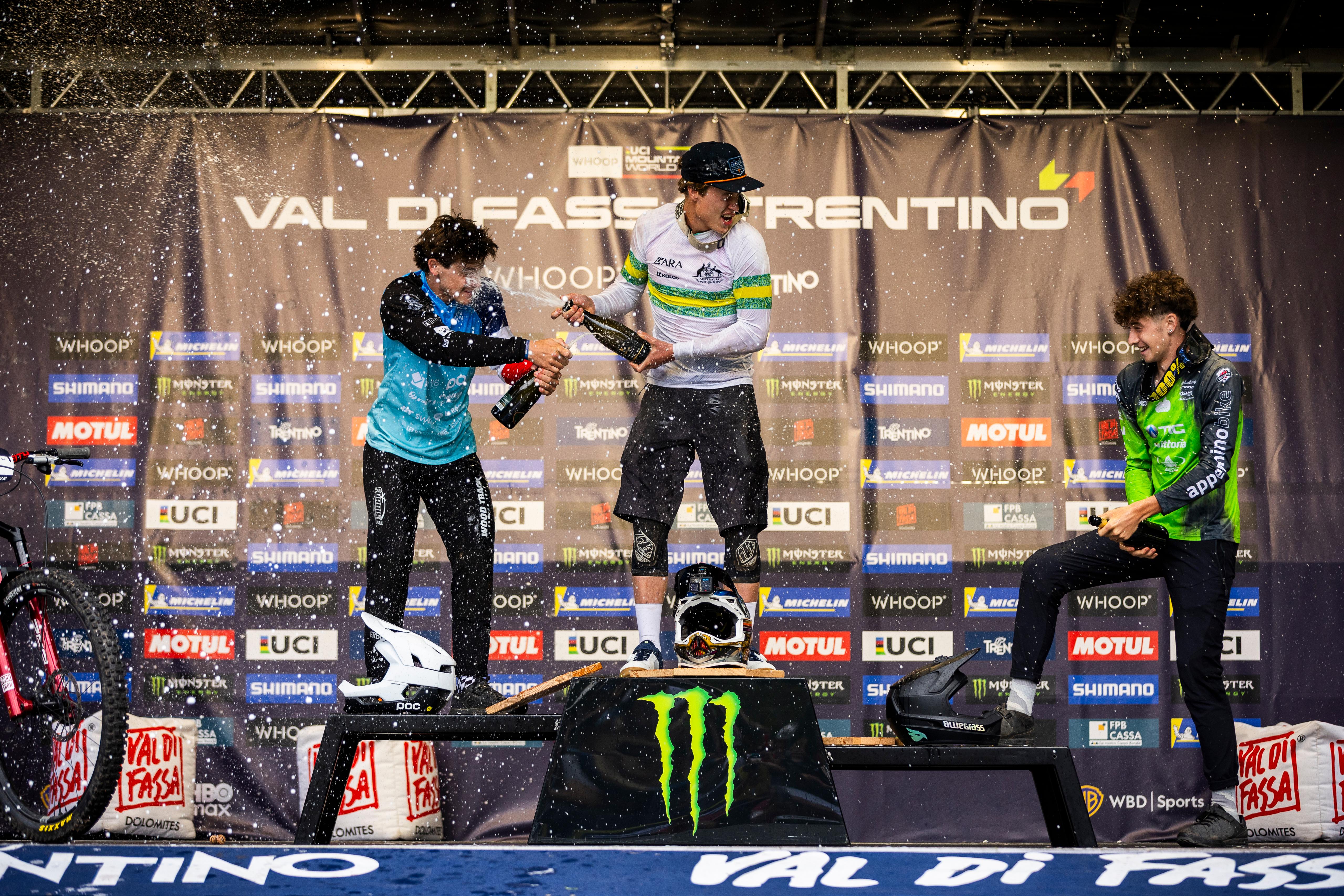 Harper Nelmes celebrates winning Round 3 of the UCI Enduro World Cup 2026 on the podium with a champagne spray
