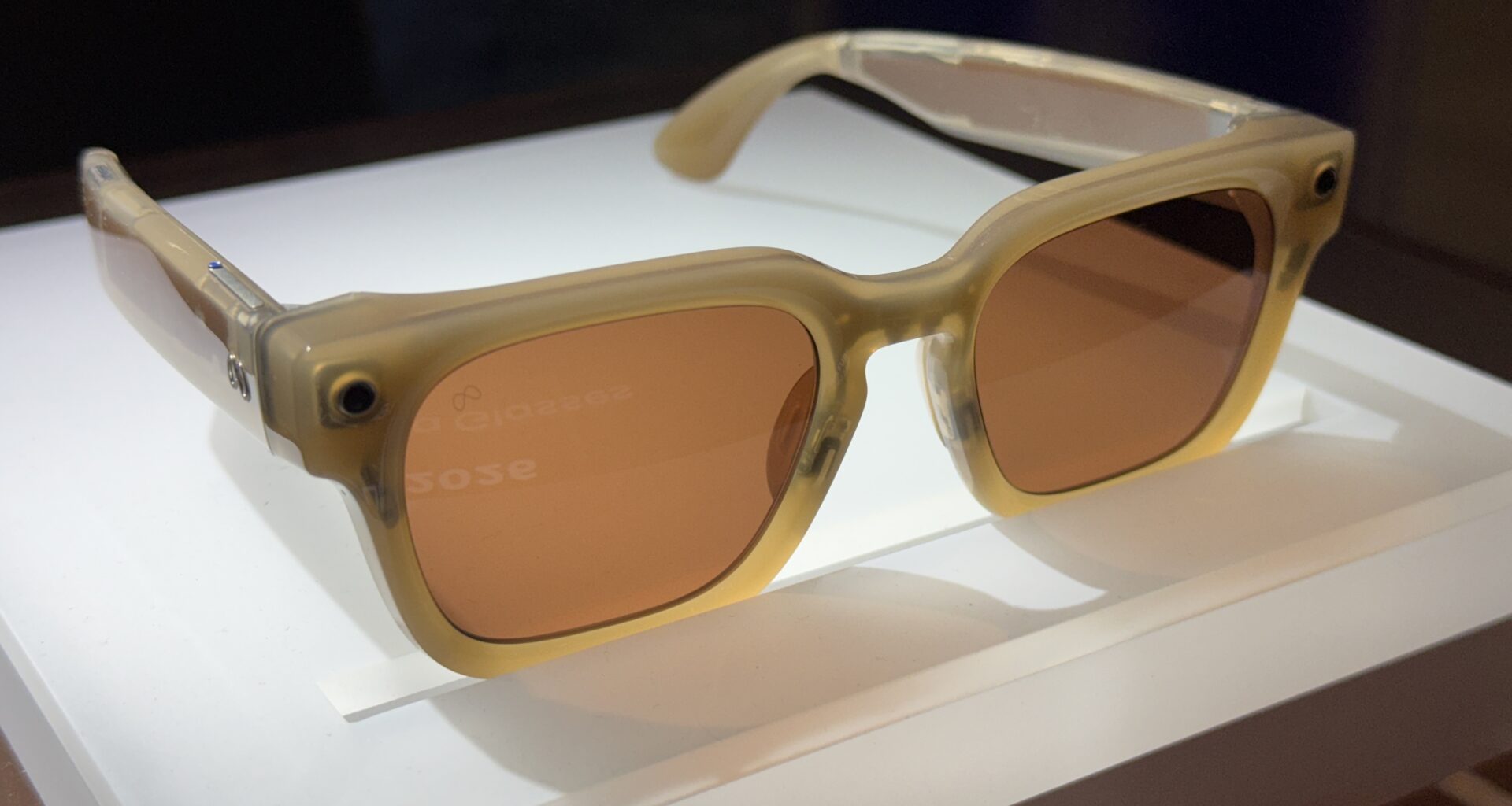 A pair of Meta smart glasses on a white pedestal