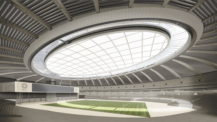 Interior view of a modern stadium with a glass-paneled roof and tiered concrete seating surrounding a green playing field.