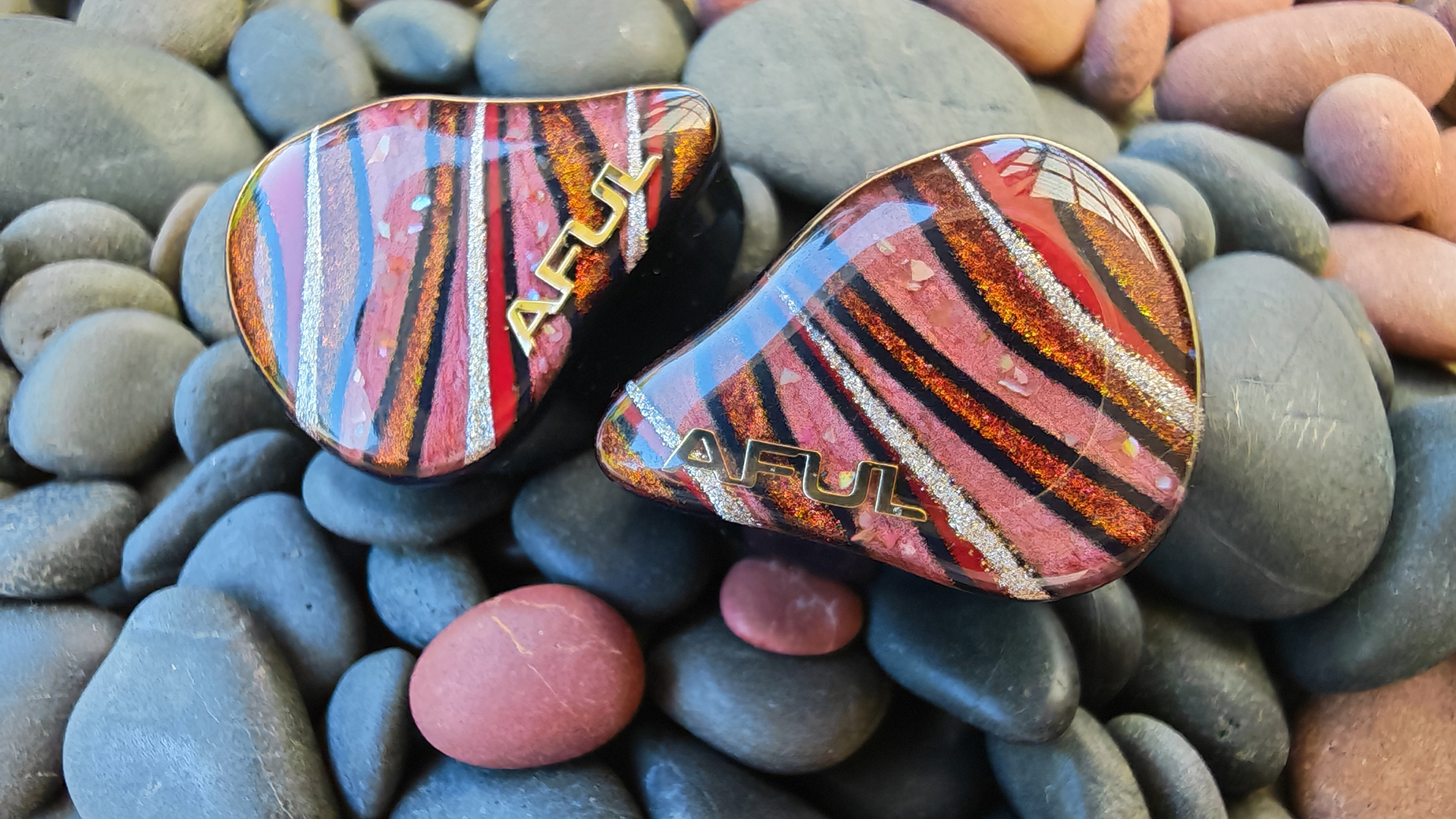 The Aful Performer 8s IEM on black and red pebbles. 