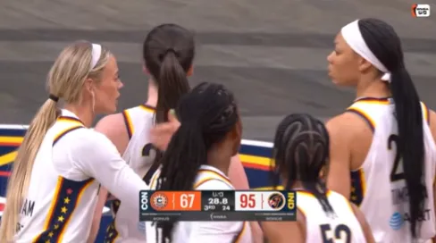 Indiana Fever star Caitlin Clark points at the scoreboard during a clash with WNBA rival Saniya Rivers of the Connecticut Sun