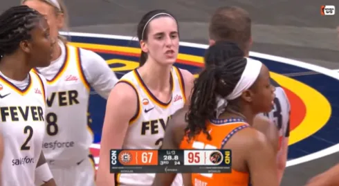 Indiana Fever star Caitlin Clark points at the scoreboard during a clash with WNBA rival Saniya Rivers