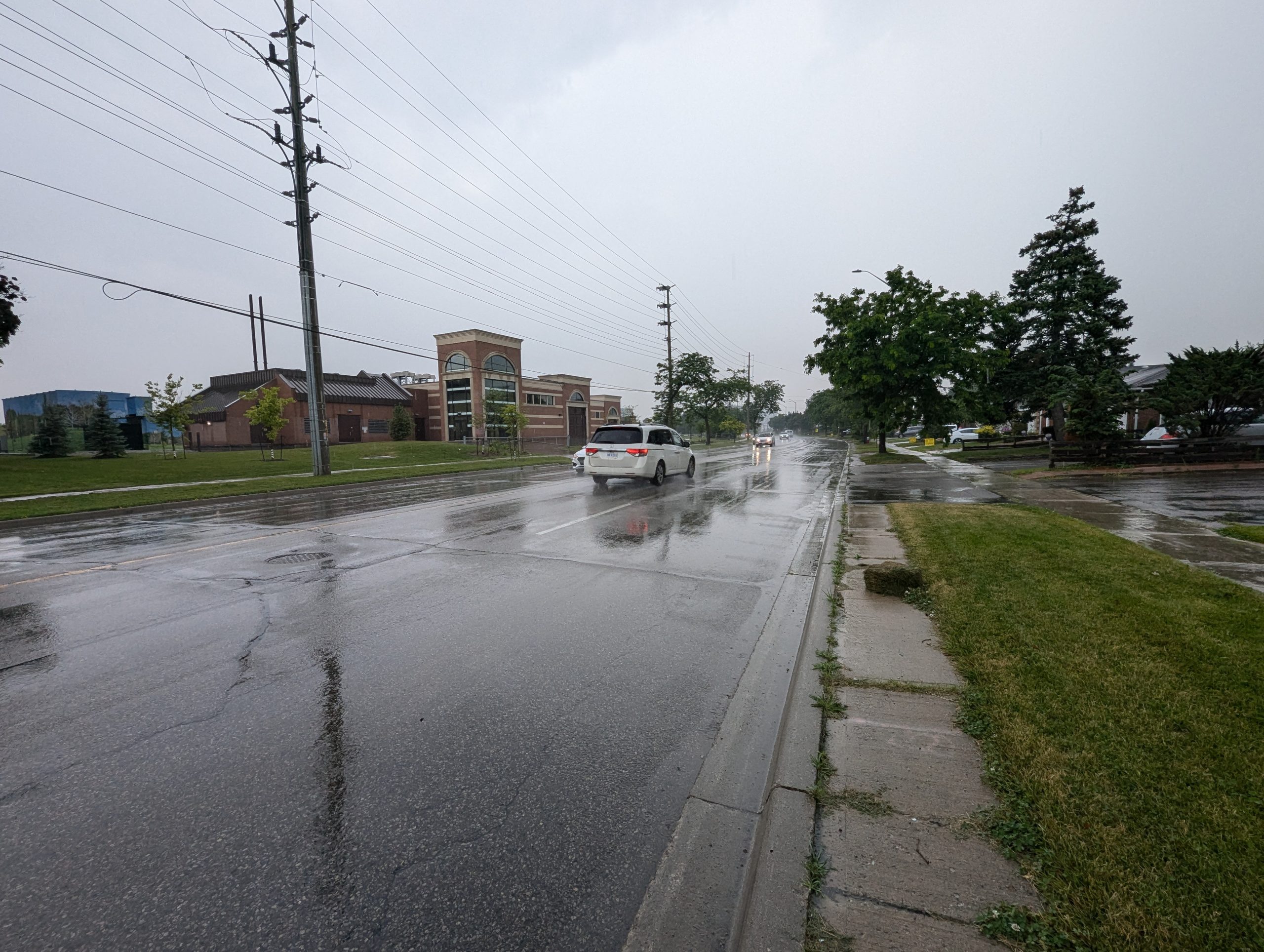 Cars driving on a wet rainy road.