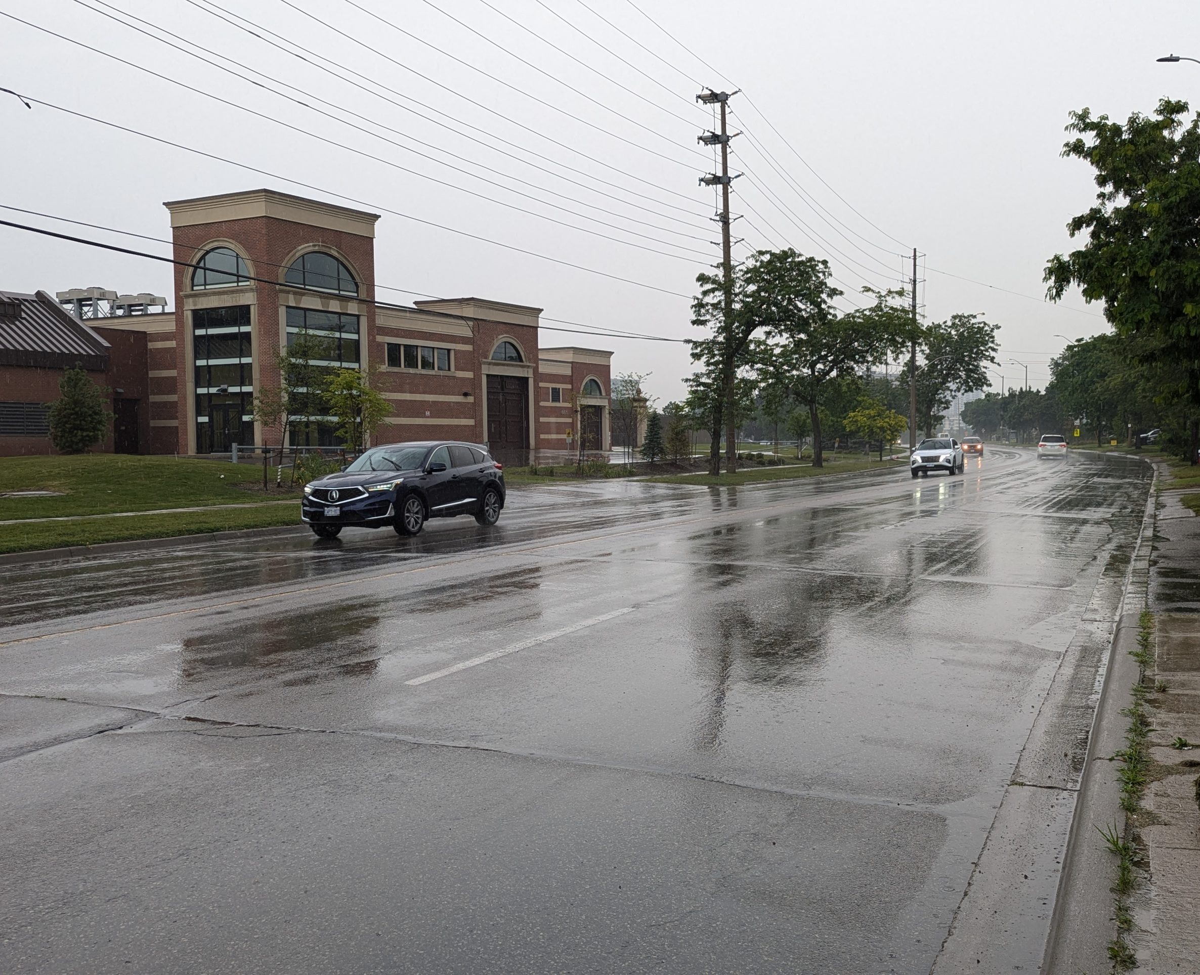 Cars driving on a wet rainy road.