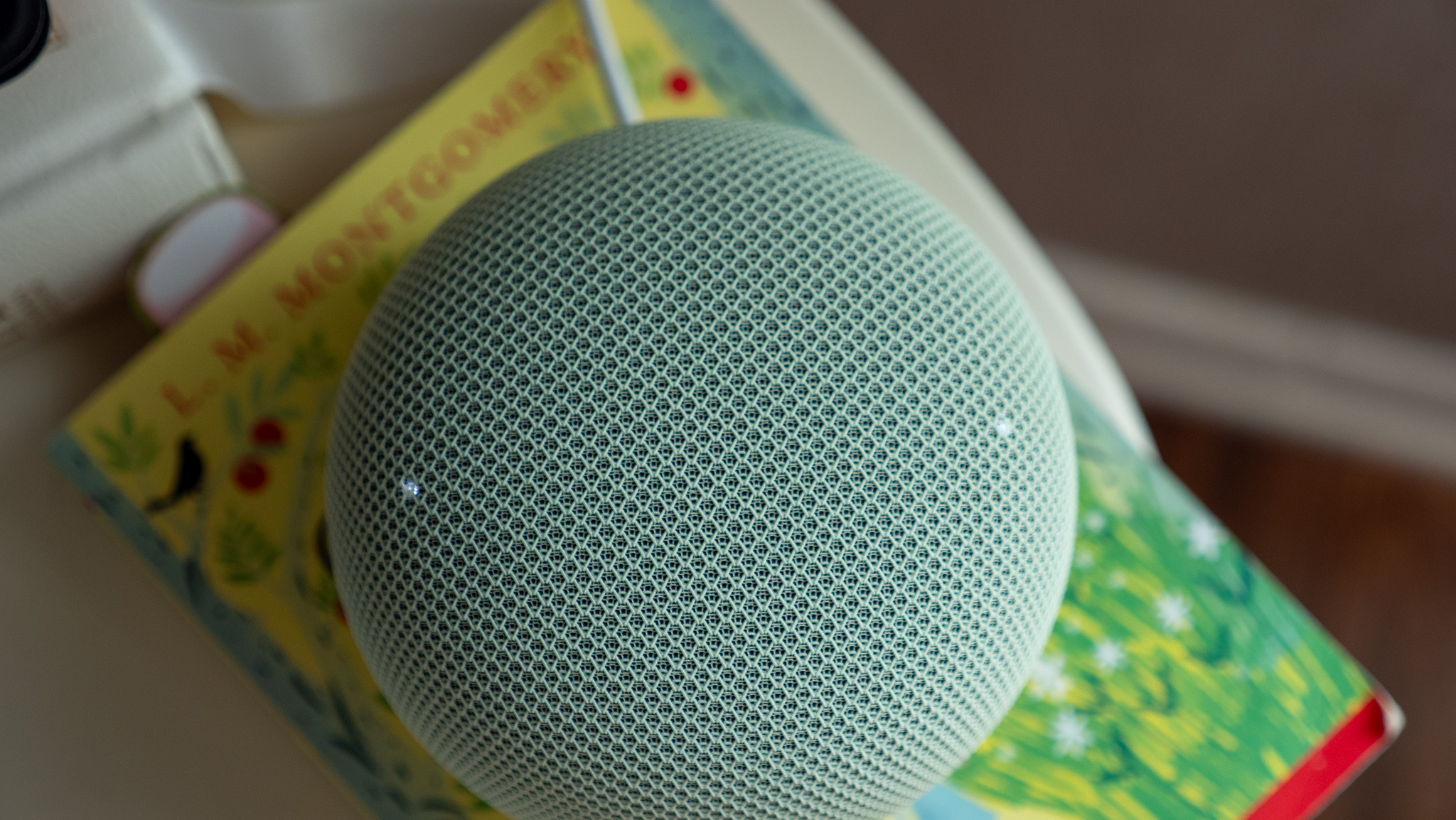 The volume adjustment buttons with lit LEDs on the Google Home Speaker