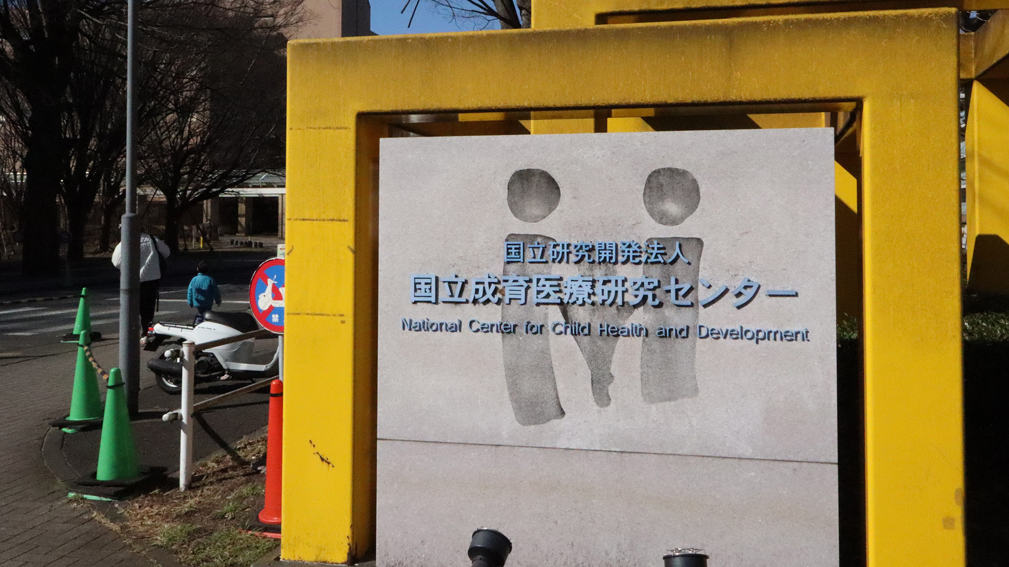 A close up of a billboard with two cartoon people and Japanese writing on it.
