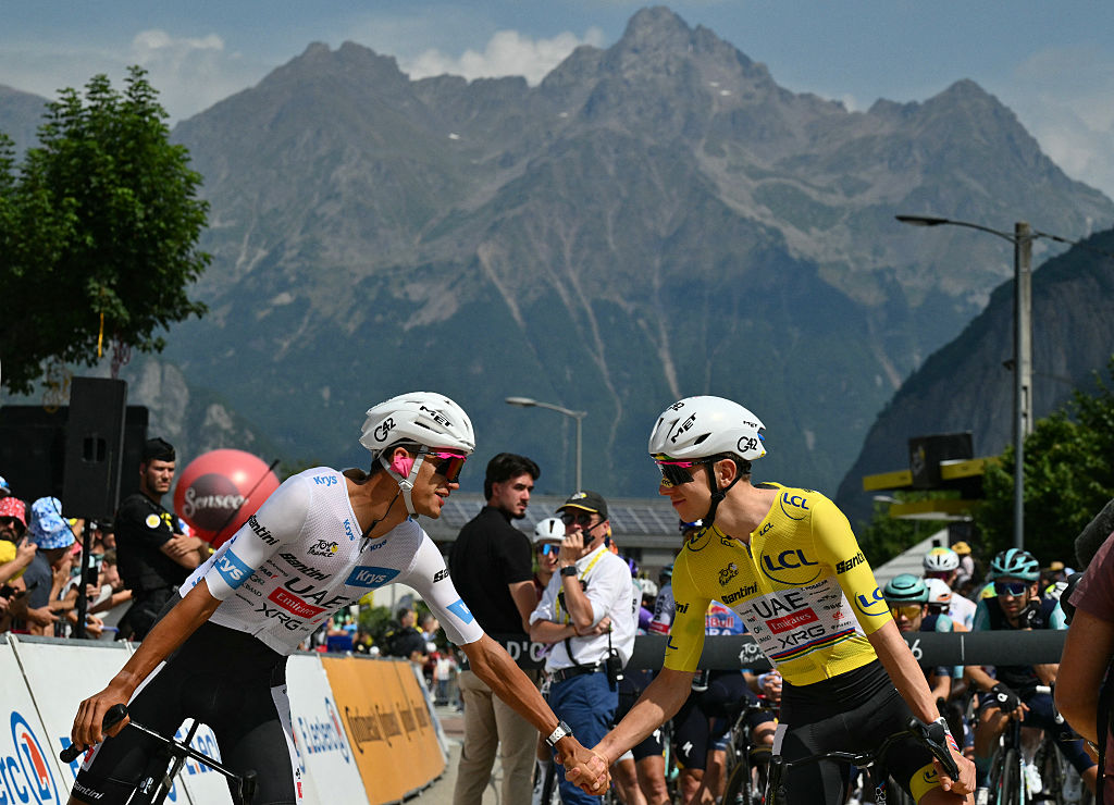 UAE Team Emirates - XRG's Slovenian rider Tadej Pogacar wearing the overall leader's yellow jersey shakes hands with UAE Team Emirates - XRG's Mexican rider Isaac Del Toro at the start of the 20th stage of the 113th edition of the Tour de France cycling race, 170,9 km between Le Bourg-d'Oisans and Alpe d'Huez in the French Alps, on July 25, 2026. (Photo by Jeff PACHOUD / AFP)