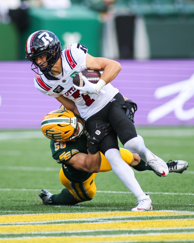 Edmonton Elks' Joel Dublanko (50) tackles Ottawa Redblacks' Ayden Eberhardt (7) during the first half of a CFL football game in Edmonton on Thursday, July 9, 2026. (Codie McLachlan/The Canadian Press via AP)