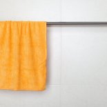 Orange microfiber towel hanging on a rack in a bathroom