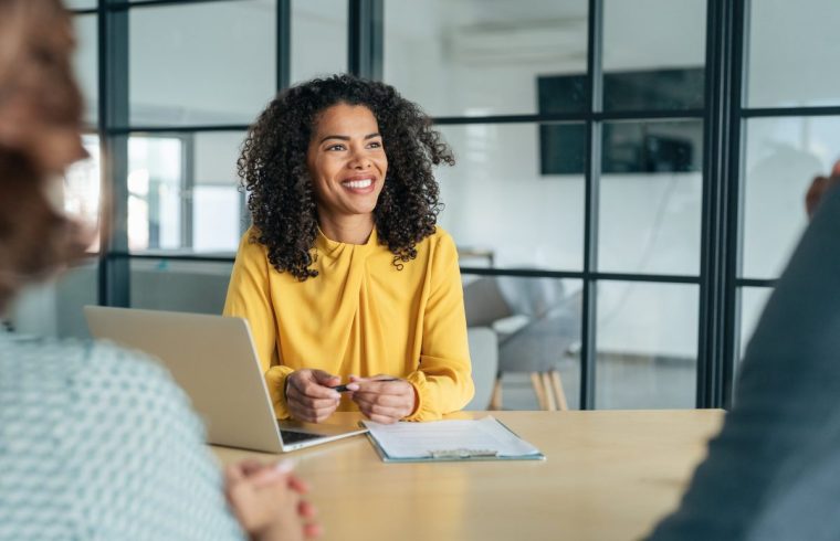 A candidate confidently presents their resume during a job interview with a panel of professionals. Company owner on a meeting with employee. Middle aged businesswoman in a conversation with a colleague. Lawyer consulting client during formal meeting. Job interview and hiring process.