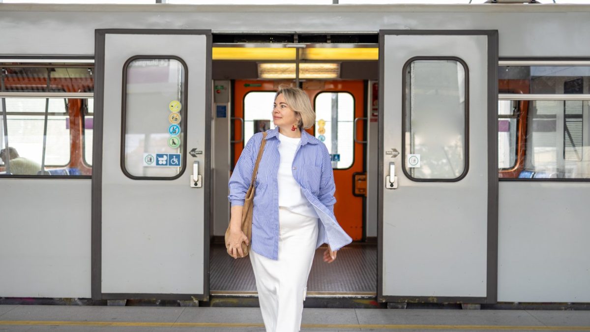 Mature businesswoman wearing casual, commuting to work in the city of Vienna. Female commuter leaving the subway train while commuting to work
