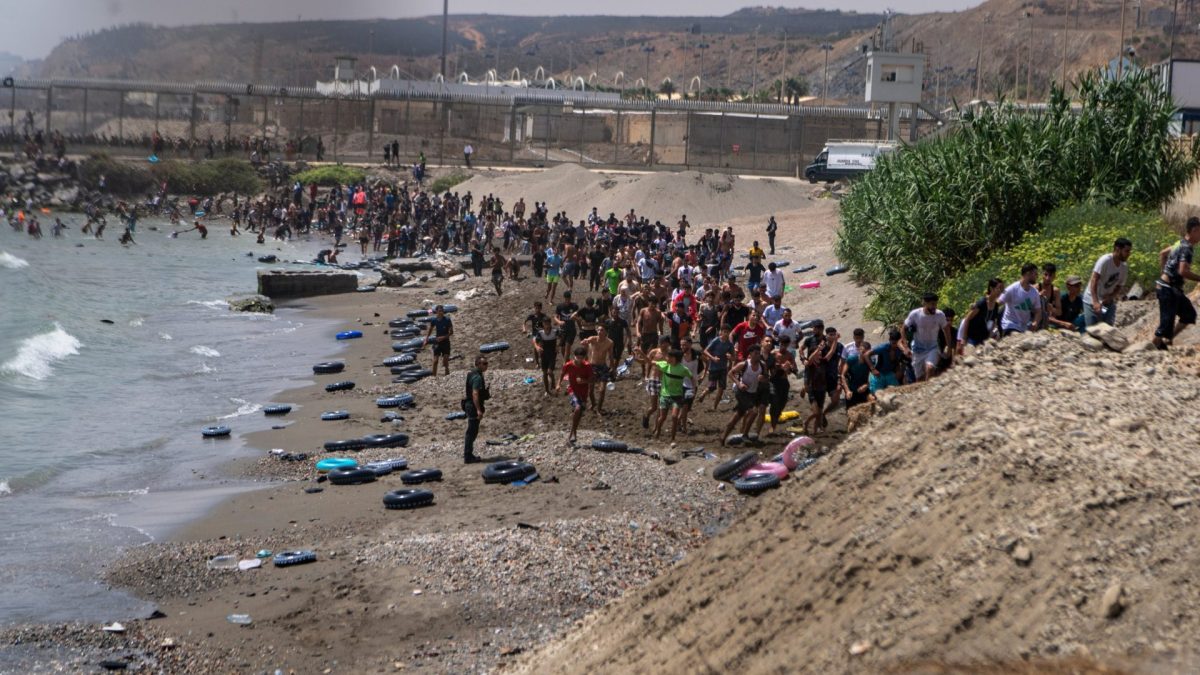 Migrants cross from Morocco into the Spanish enclave of Ceuta, Thursday, July 30, 2026. (AP Photo/Antonio Sempere)