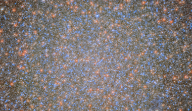 An image of the globular cluster Omega Centauri, a collection of myriad stars colored red, white, and blue on the black background of space.