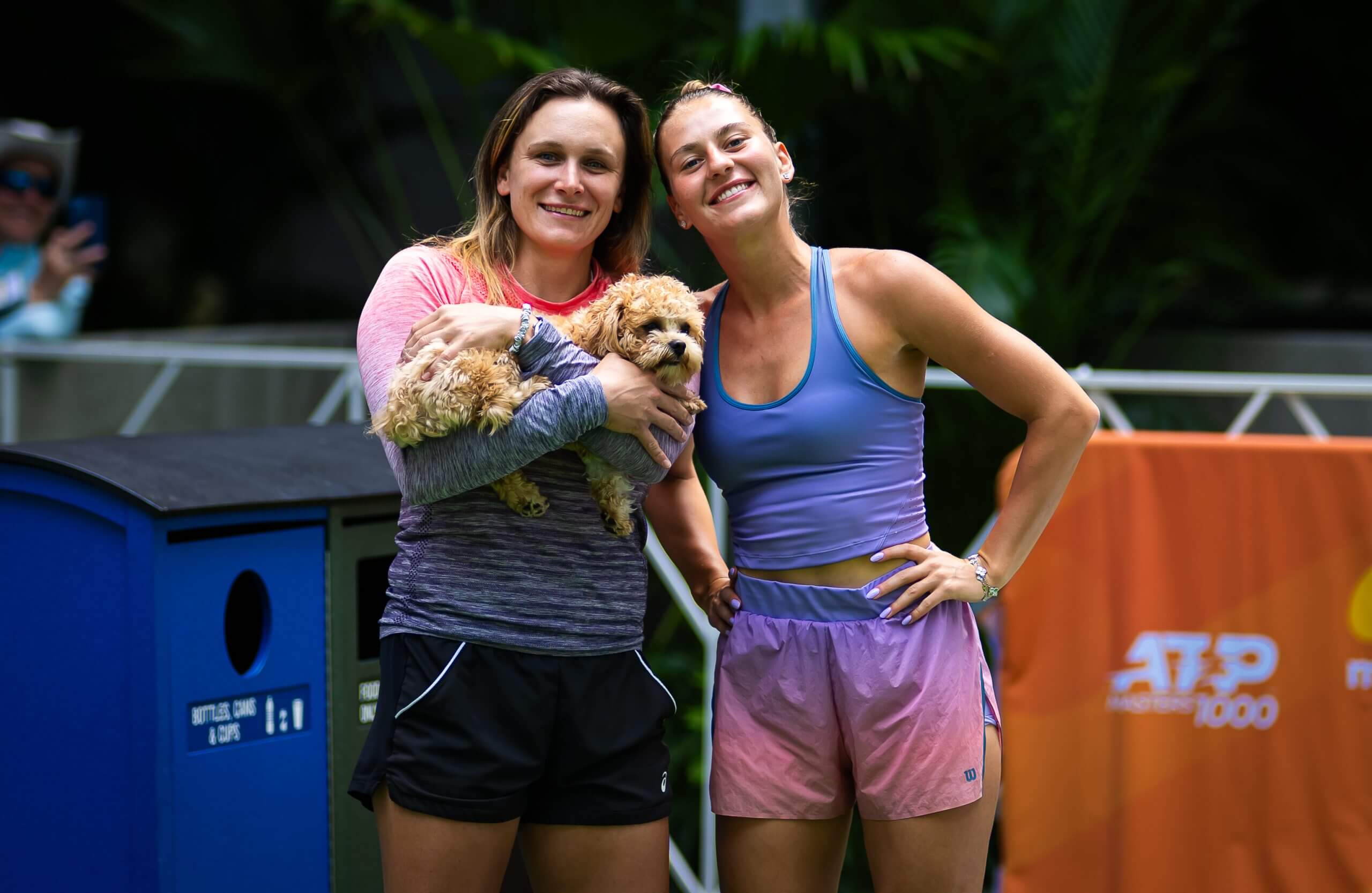 Sandra Zaniewska (and Marta Kostyuk stand outside together, with Zaniewska holding a small dog in her arms.