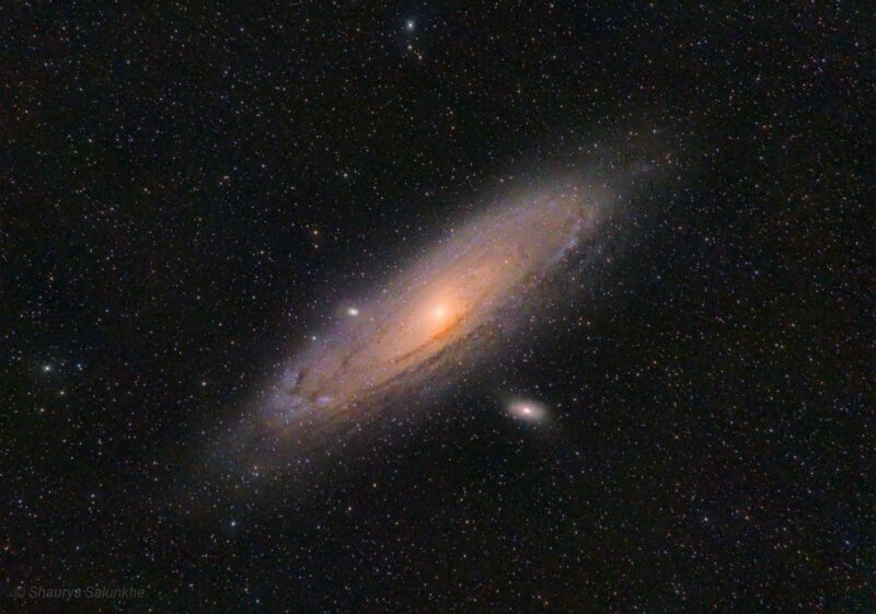 Oblique view of a large, glowing spiral with bright center, with thousands of foreground stars.