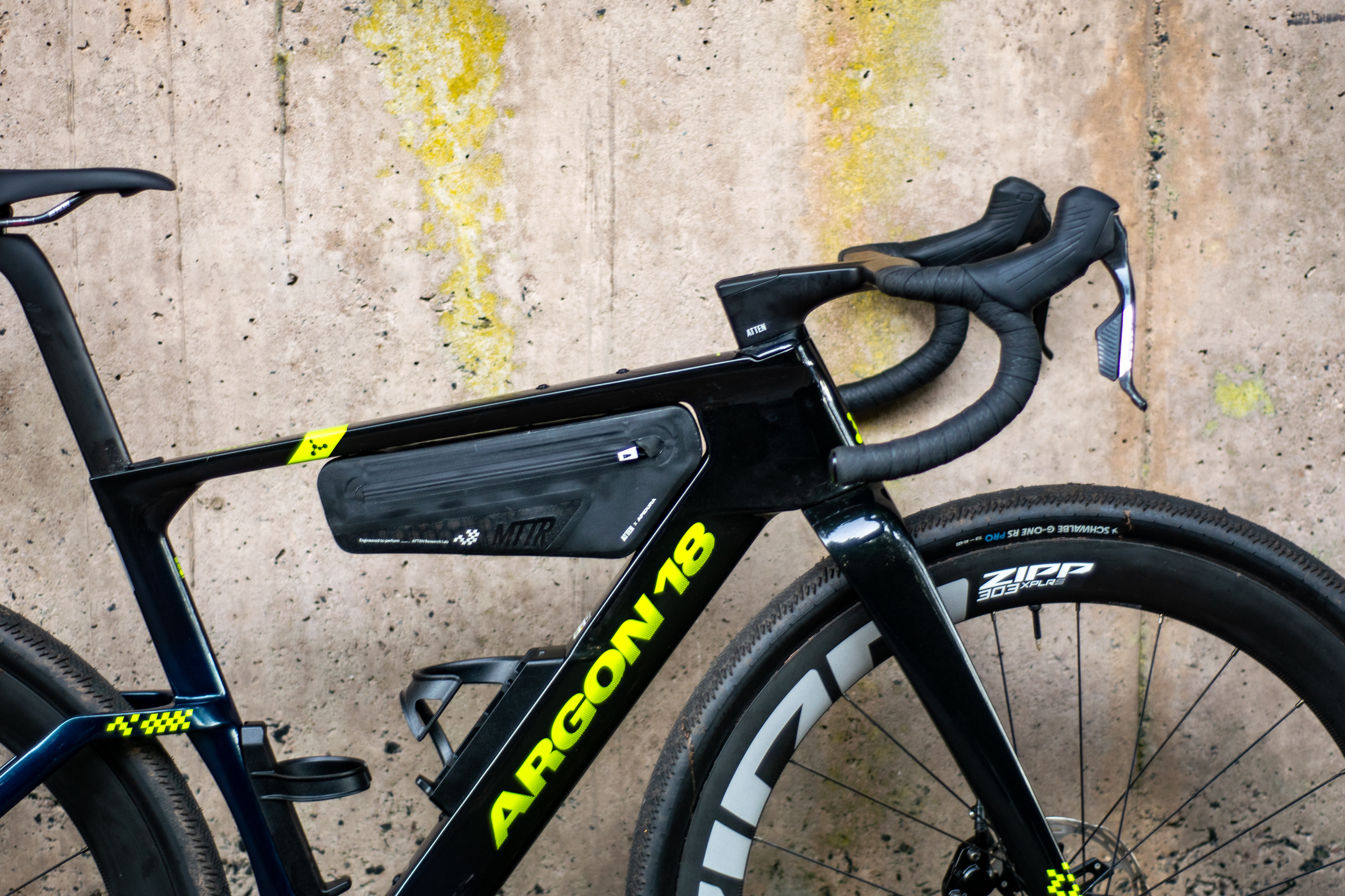 An Argon 18 Anti Matter gravel bike leaning against a concrete wall.
