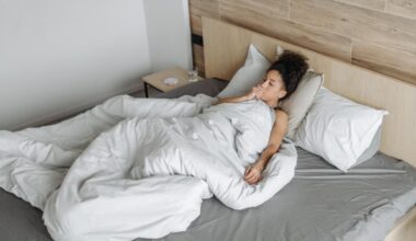 Sick woman lying in bed covered with sheets