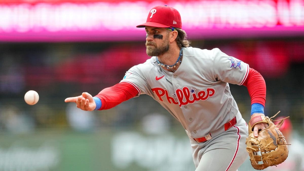 Philadelphia Phillies 1B Bryce Harper tosses the ball towards first base vs. the Milwaukee Brewers at American Family Field in Wisconsin.
