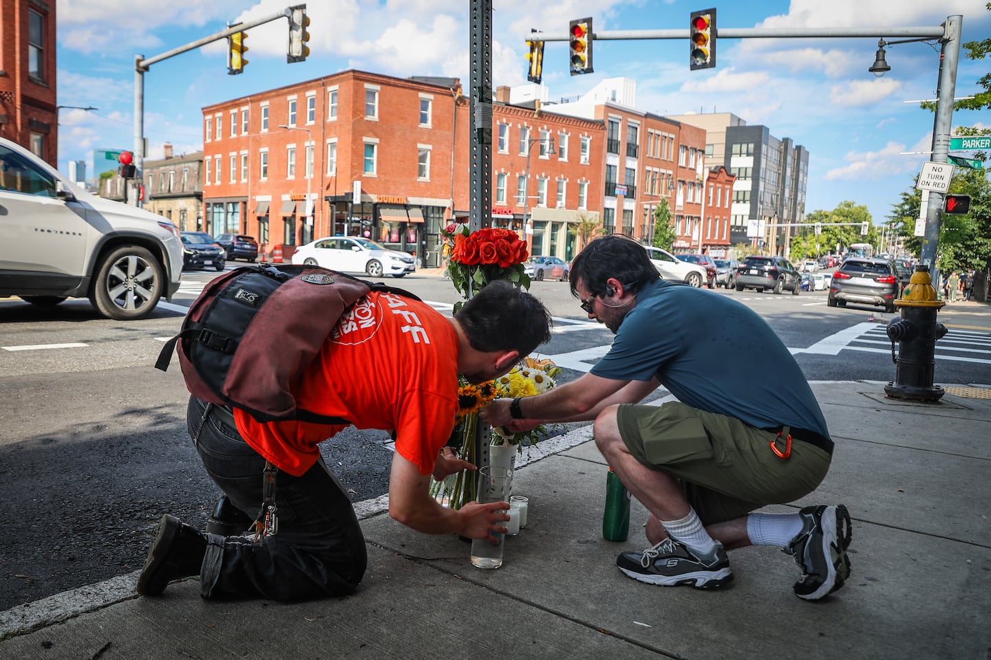 Two people brought flowers on July 9 to the intersection of Tremont and Parker streets in Boston, where Louisa Gag, 36, was fatally struck by a truck while cycling. Gag was a bike share and transportation planner for the city of Boston and a cycling advocate.
